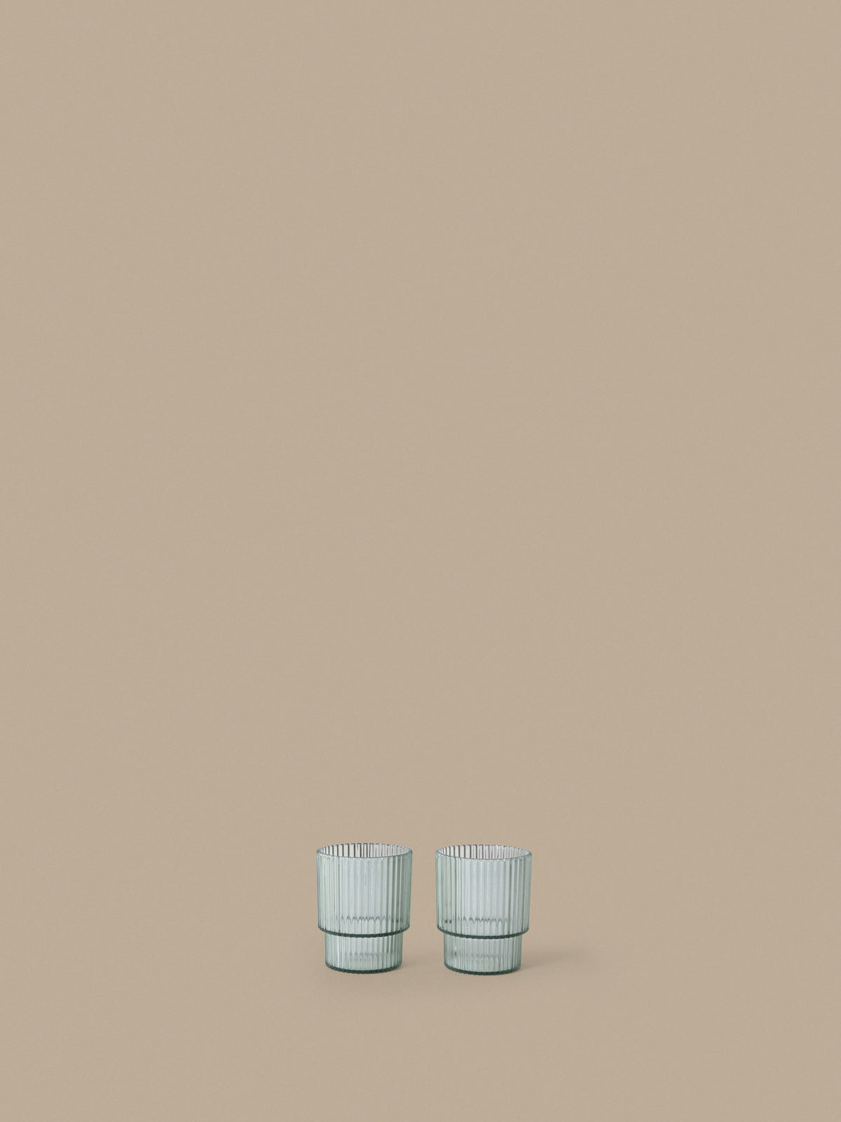 Zwei Ripple Kinder-Becher von Ferm Living aus klarem Tritan-Kunststoff mit geriffelter Oberfläche und geometrischer, runder Silhouette.