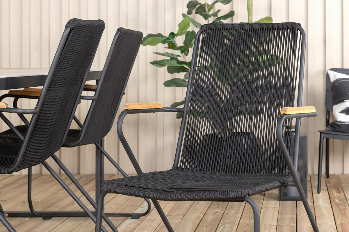 Zwei schwarze Esszimmerstühle aus Aluminium und Teakholz neben einem rechteckigen Esstisch mit Glas-Teak-Platte in Hellgrau.
