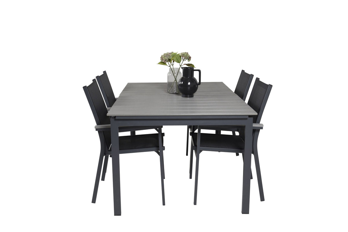 Rechteckiger Esstisch aus Aintwood mit Aluminiumgestell in Anthrazit, dazu zwei stapelbare Stühle mit pulverbeschichteter Oberfläche.