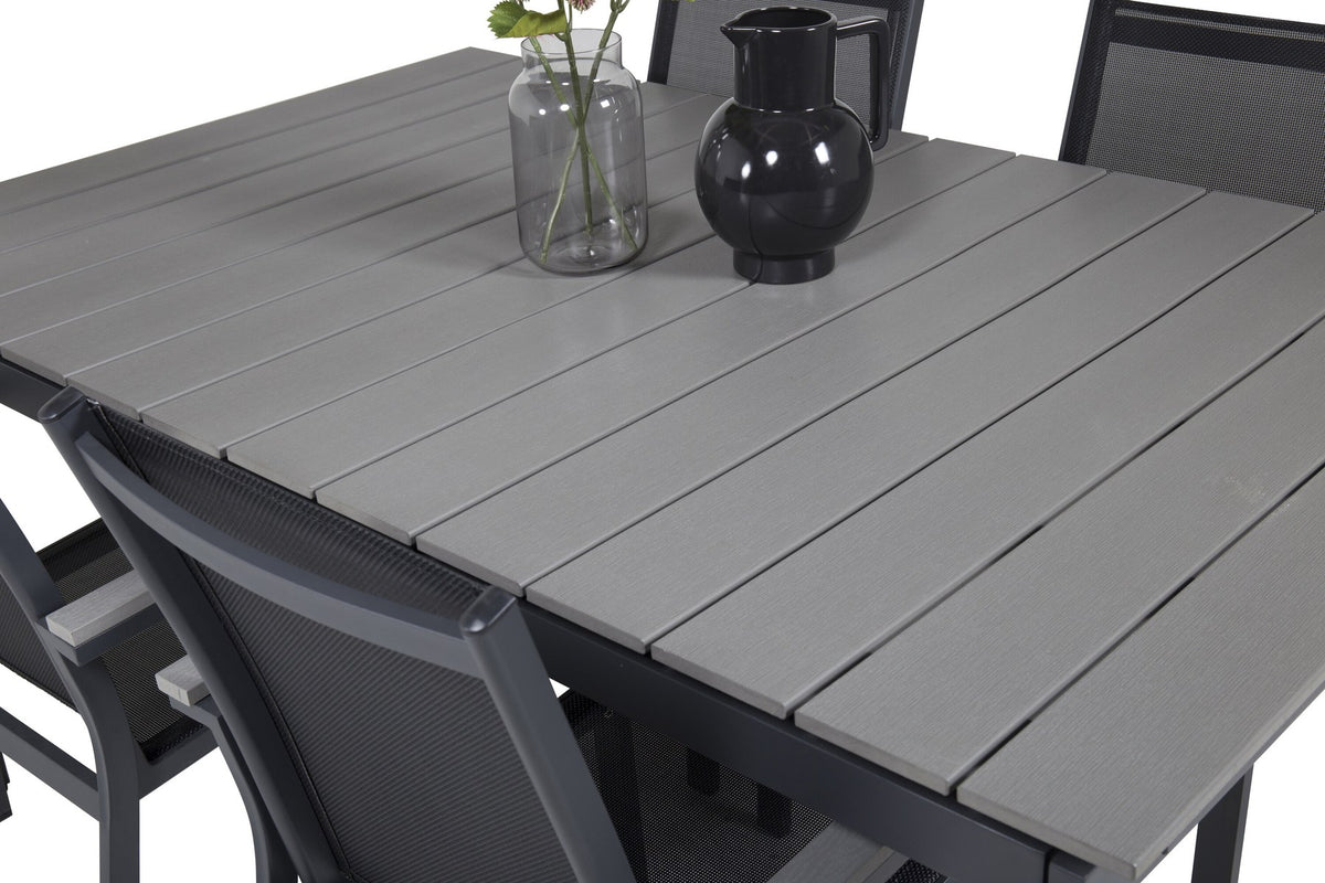 Rechteckiger Esstisch aus Aintwood mit Aluminiumgestell in Anthrazit, dazu zwei stapelbare Stühle mit pulverbeschichteter Oberfläche.