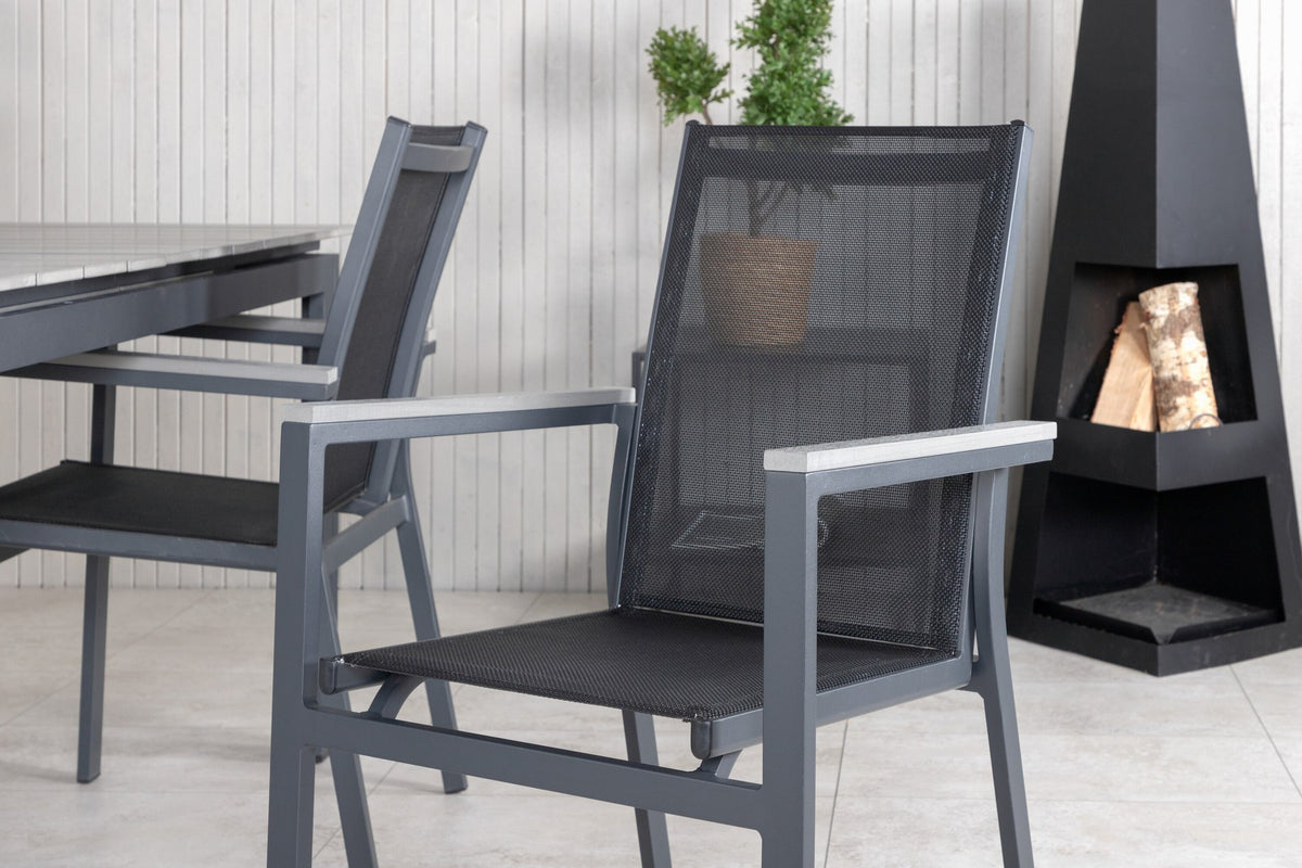 Rechteckiger Esstisch aus Aintwood mit Aluminiumgestell in Anthrazit, dazu zwei stapelbare Stühle mit pulverbeschichteter Oberfläche.