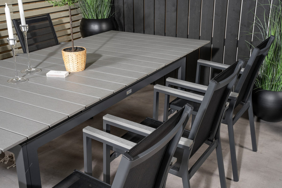 Rechteckiger Esstisch aus Aintwood mit Aluminiumgestell in Anthrazit, dazu zwei stapelbare Stühle mit pulverbeschichteter Oberfläche.