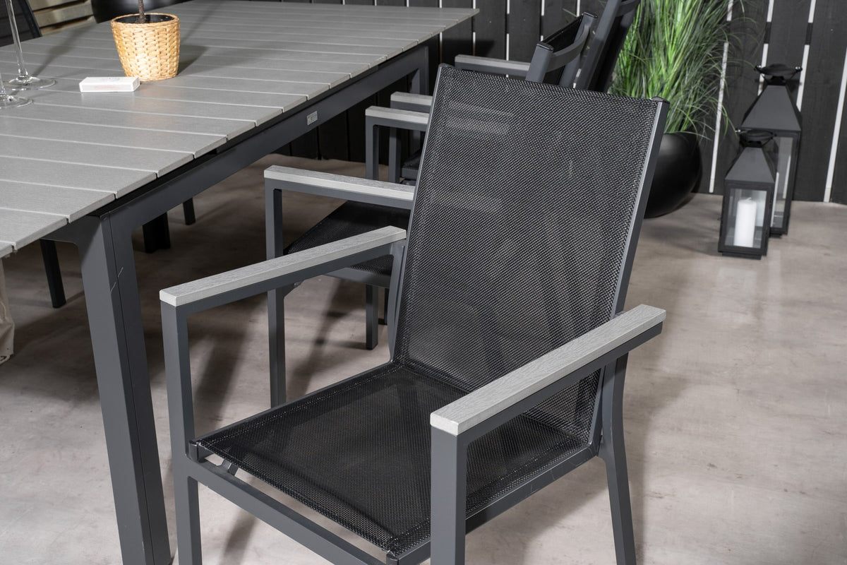 Rechteckiger Esstisch aus Aintwood mit Aluminiumgestell in Anthrazit, dazu zwei stapelbare Stühle mit pulverbeschichteter Oberfläche.
