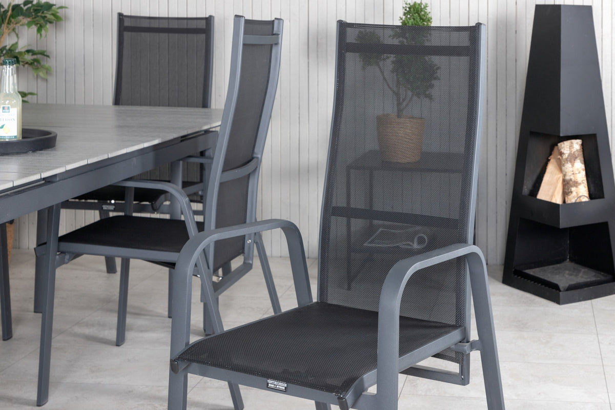 Schwarzer ausziehbarer Gartentisch Levels mit grauer Aintwood-Tischplatte und zwei stapelbaren Copacabana Sesseln aus Aluminium und Aintwood.
