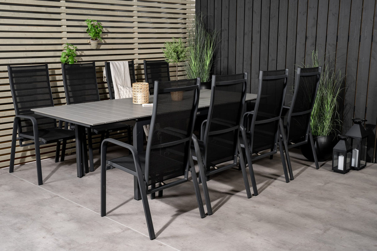 Schwarzer ausziehbarer Gartentisch Levels mit grauer Aintwood-Tischplatte und zwei stapelbaren Copacabana Sesseln aus Aluminium und Aintwood.