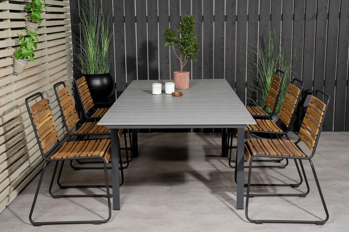 Rechteckiger Gartentisch mit grauer Aintwood-Tischplatte und schwarzem Stahlgestell, daneben zwei Esszimmerstühle aus Aintwood und Aluminium in Natur.