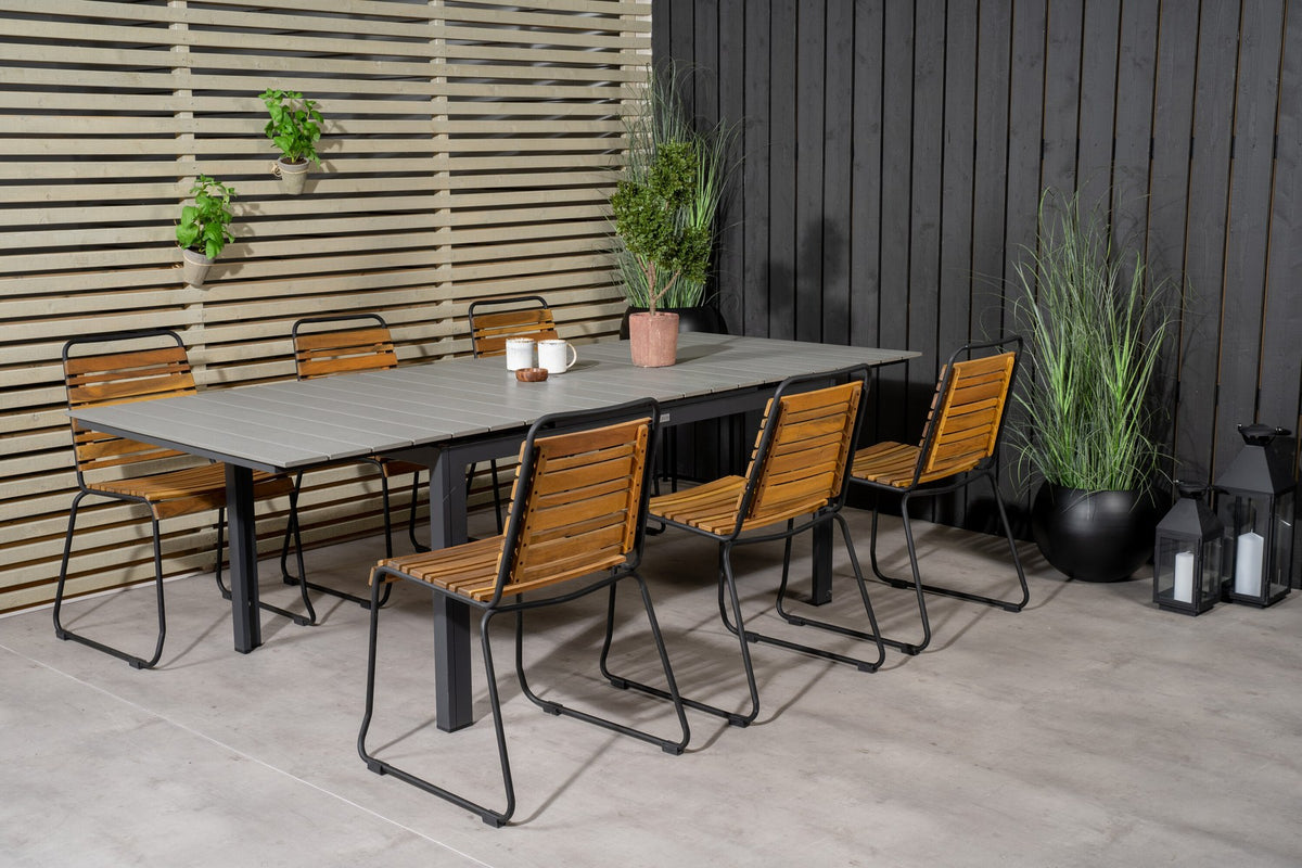 Rechteckiger Gartentisch mit grauer Aintwood-Tischplatte und schwarzem Stahlgestell, daneben zwei Esszimmerstühle aus Aintwood und Aluminium in Natur.