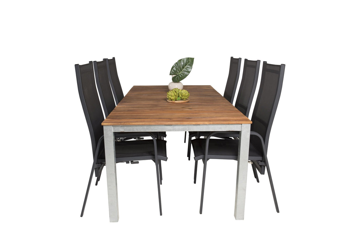 Zwei schwarze Relaxsessel aus Akazie und Stahl neben einem rechteckigen Esstisch mit Akazie-Tischplatte in Natur und Aluminiumbeinen.