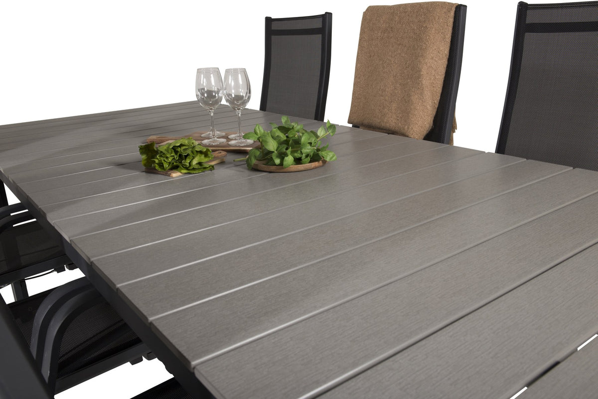 Rechteckiger Gartentisch mit grauer Aintwood-Platte und Aluminiumgestell, daneben zwei stapelbare Copacabana-Relaxsessel in Schwarz.