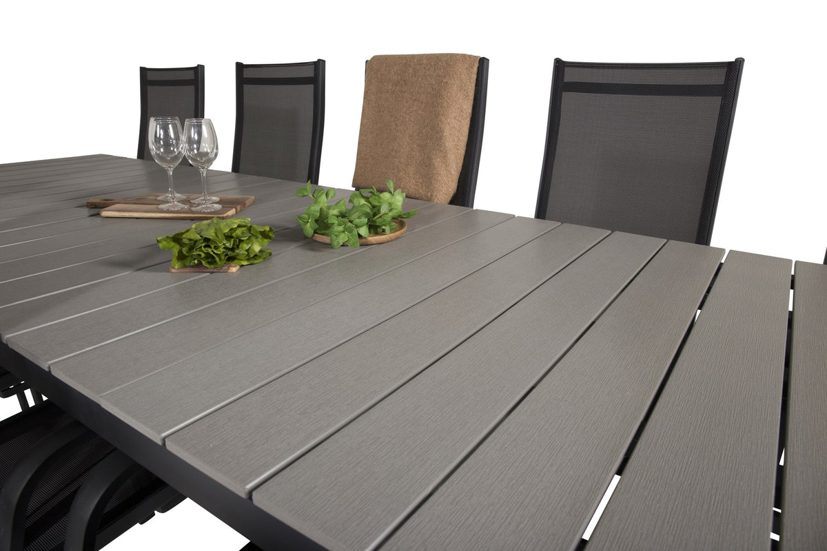 Rechteckiger Gartentisch mit grauer Aintwood-Platte und Aluminiumgestell, daneben zwei stapelbare Copacabana-Relaxsessel in Schwarz.