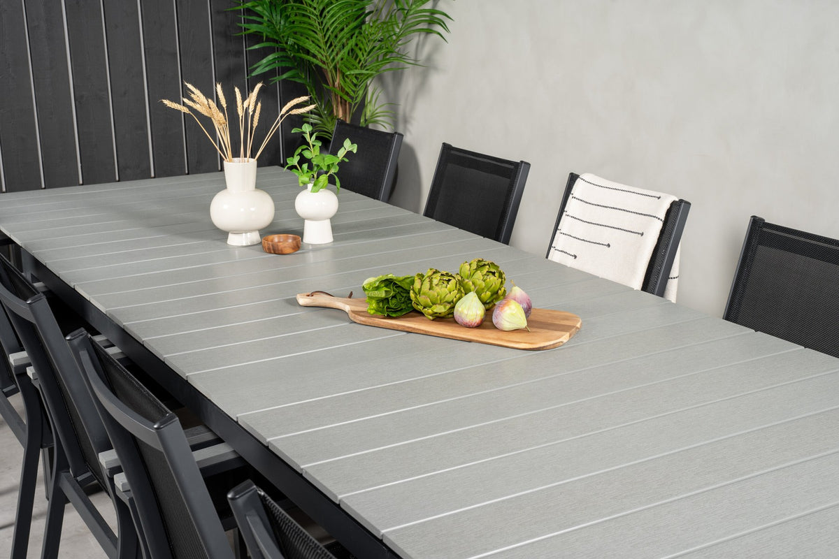 Rechteckiger Esstisch mit grauer Aintwood-Tischplatte und Aluminiumbeinen, dazu zwei stapelbare Stühle in Anthrazit mit pulverbeschichtetem Gestell.