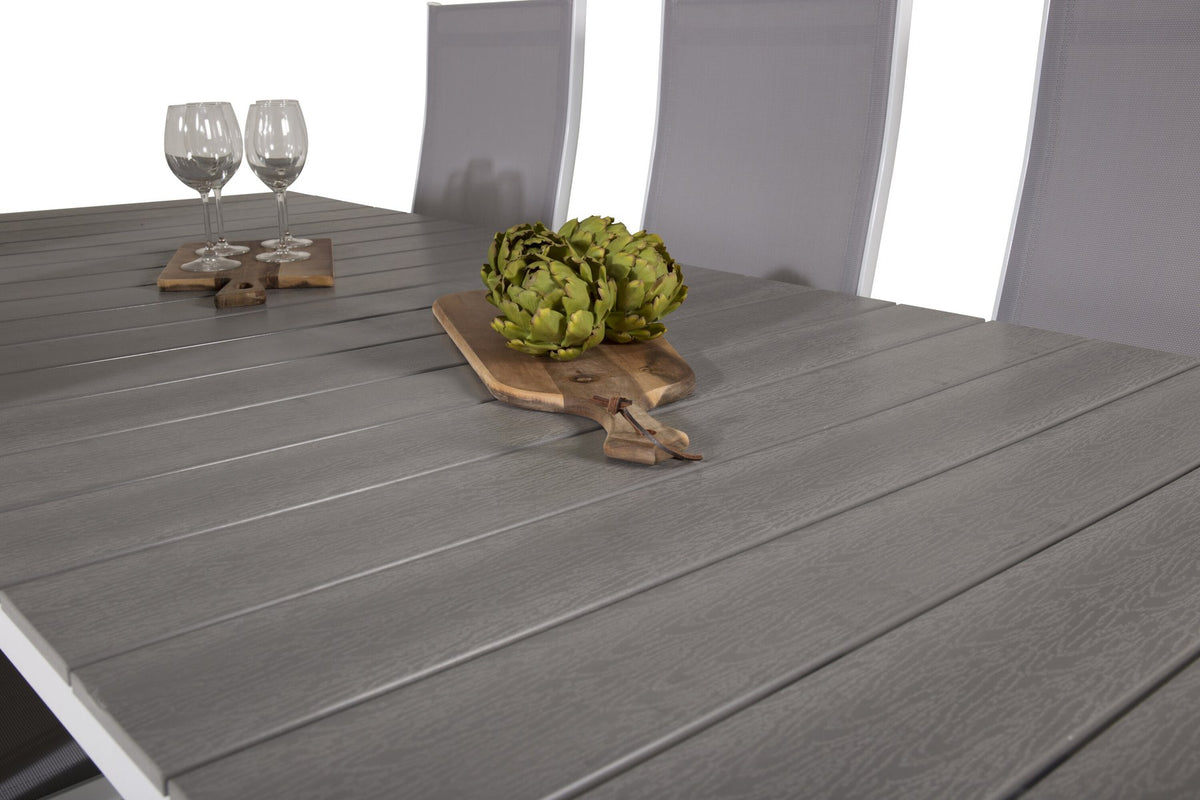 Gartentischset mit ausziehbarem Levels Esstisch aus Aluminium und Aintwood sowie acht stapelbaren Copacabana Stühlen mit grauem Textilene-Bezug.