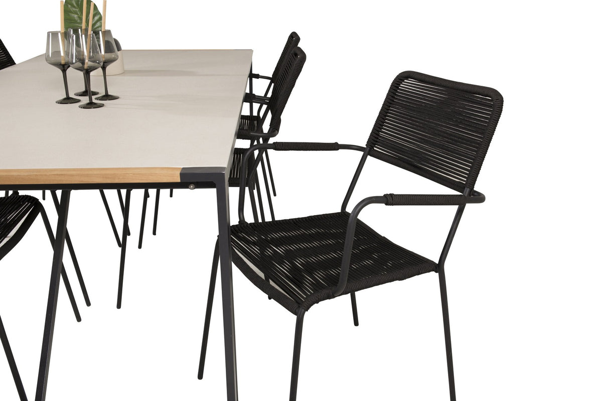 Zwei schwarze Esszimmerstühle mit geflochtener Seilsitzfläche und Aluminiumgestell neben rechteckigem Esstisch mit Glas-Teak-Platte und Stahlbeinen.