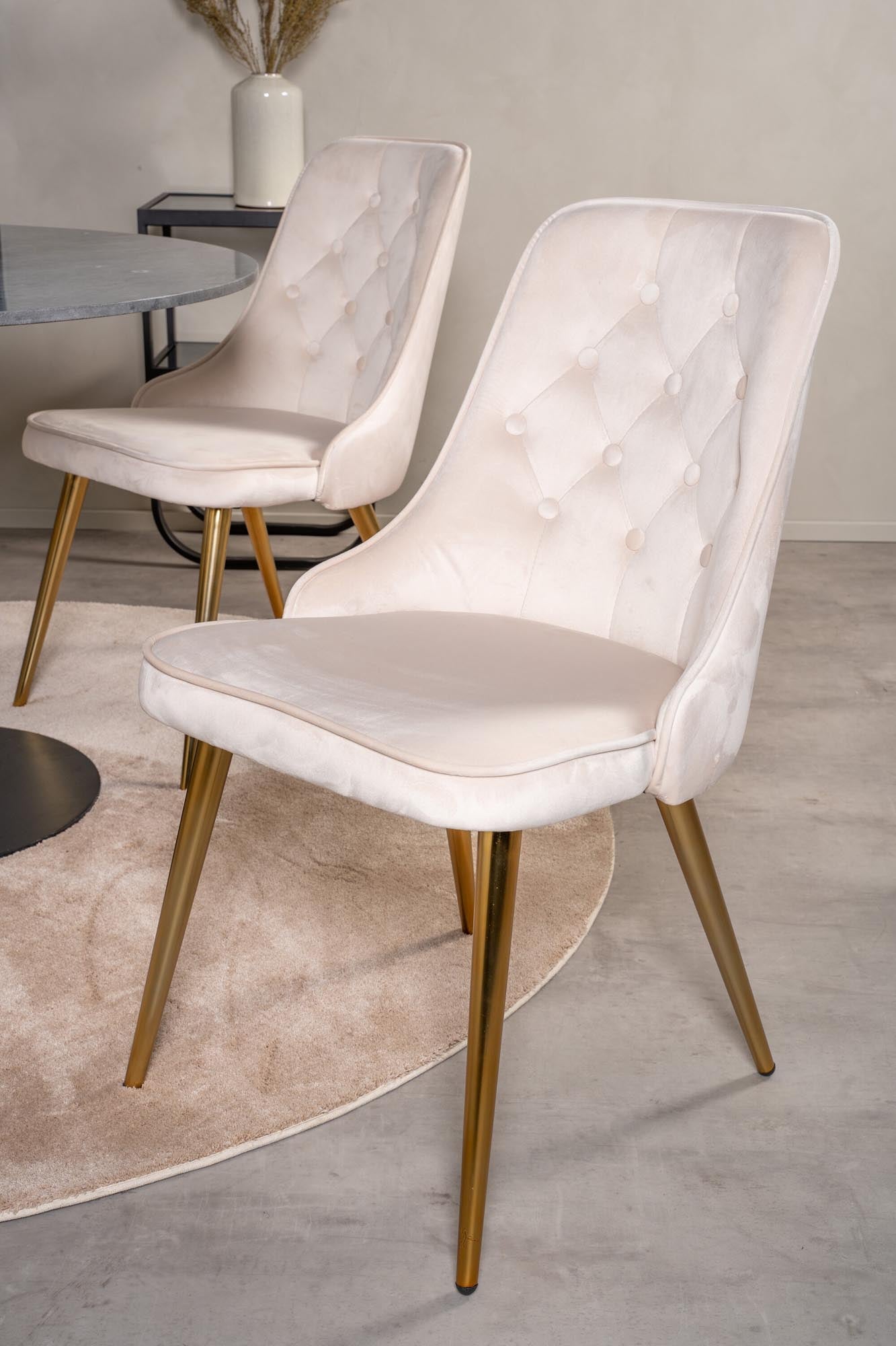 Stilvolles Esszimmerset mit rundem Tisch und vier edlen Samtstühlen.