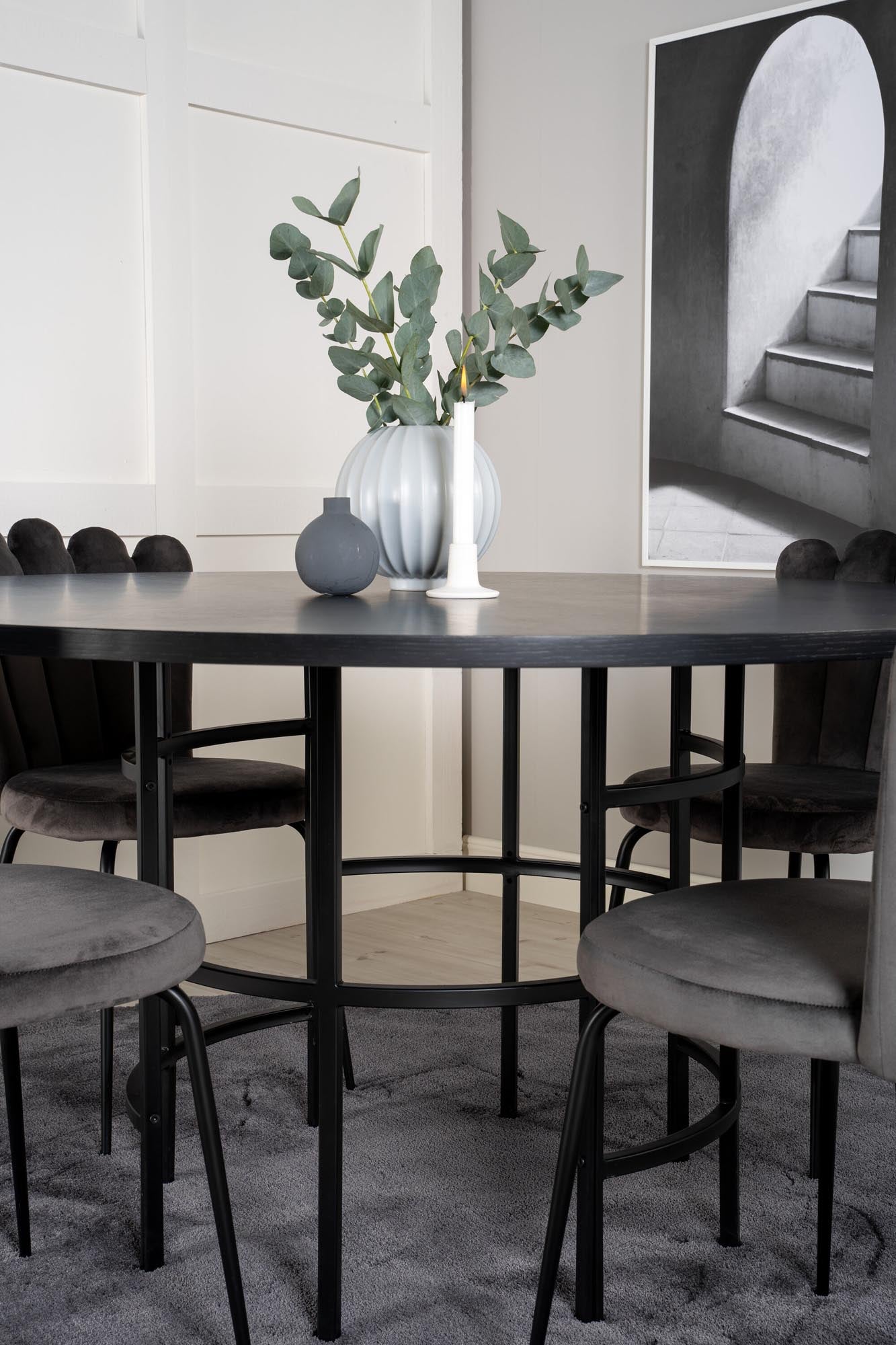 Stilvolles Esszimmerset mit runden Tisch und bequemen Samtstühlen, ideal für gemütliche Abende und Dinnerpartys.