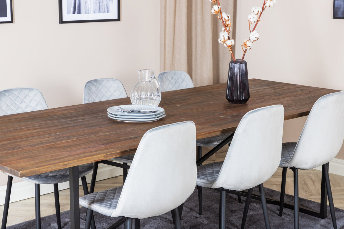 Esstisch mit Teak-Tischplatte in Natur und Stahlgestell, dazu Stühle mit schwarzem Stahlrahmen und grauem Polyester-Samt-Bezug.