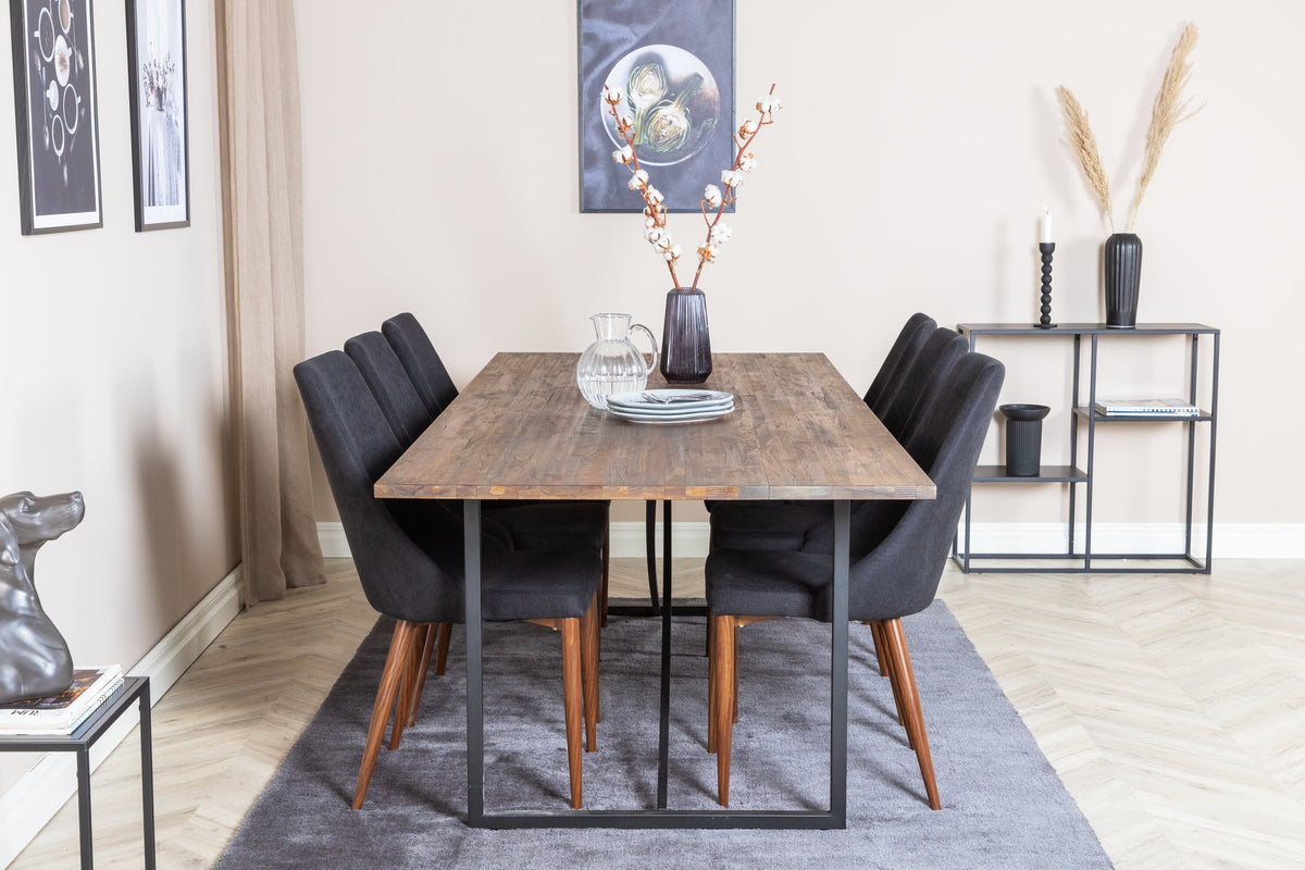 Zwei schwarze Esszimmerstühle mit Stahlgestell und Polsterbezug sowie rechteckiger Esstisch aus Teakholz mit Stahlbeinen, Farbe Natur.