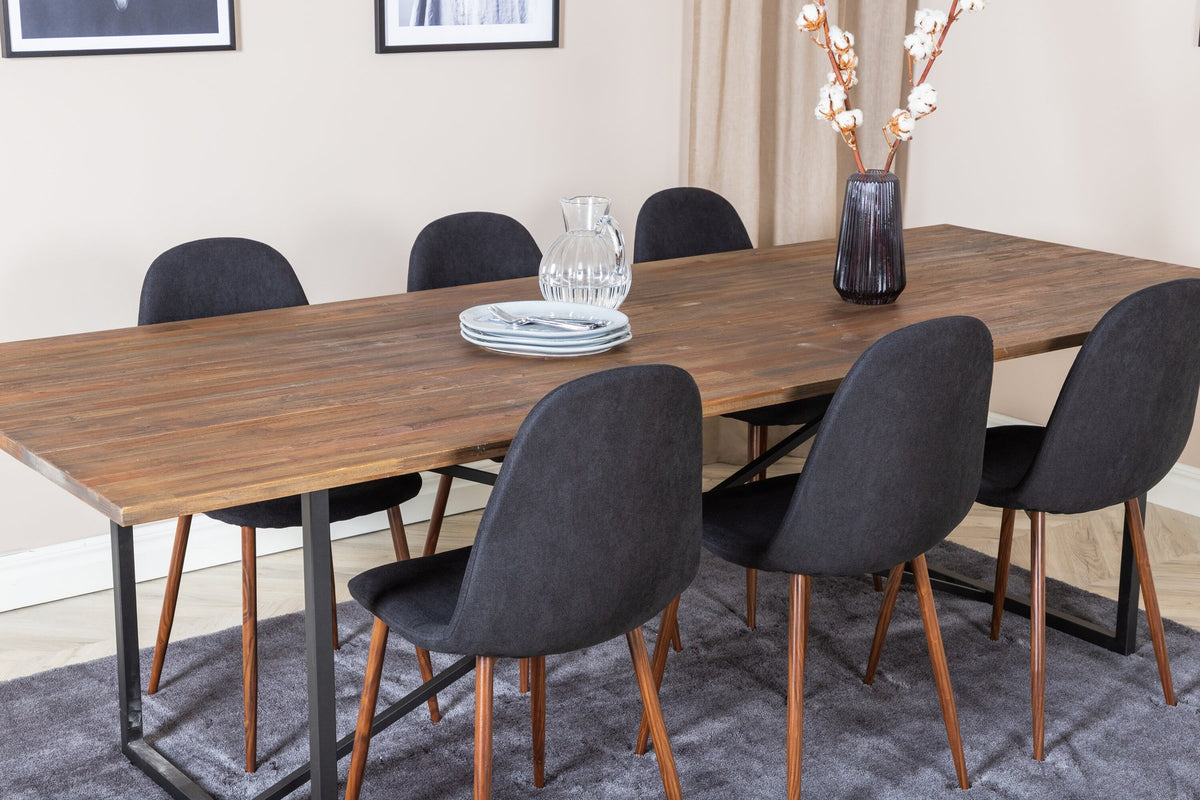Esstisch mit Teak-Tischplatte in Natur und Stahlgestell, dazu Stühle mit schwarzem Stahlrahmen und grauem Polyester-Samt-Bezug.