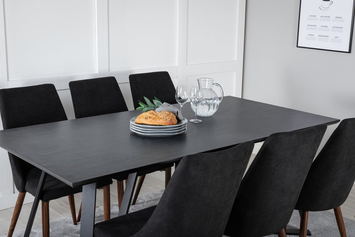 Rechteckiger Esstisch mit schwarzer MDF-Platte und Stahlgestell, kombiniert mit zwei schwarzen Esszimmerstühlen aus MDF und Stahl.