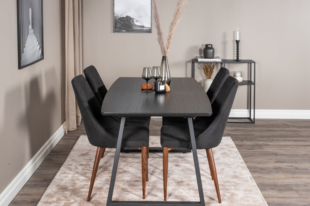 Zwei schwarze Esszimmerstühle mit Stahlbeinen und ausziehbarer schwarzer Esstisch mit MDF-Platte, Serie Leone & Inca von Venture Home.