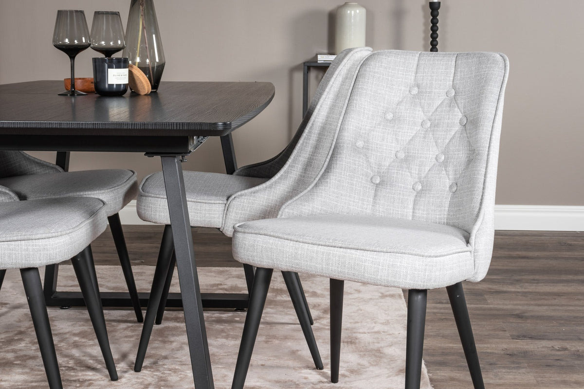 Rechteckiger Esstisch Inca in Schwarz mit ausziehbarer MDF-Platte und Stahlbeinen, daneben zwei gepolsterte Velvet-Esszimmerstühle in Grau von Venture Home.
