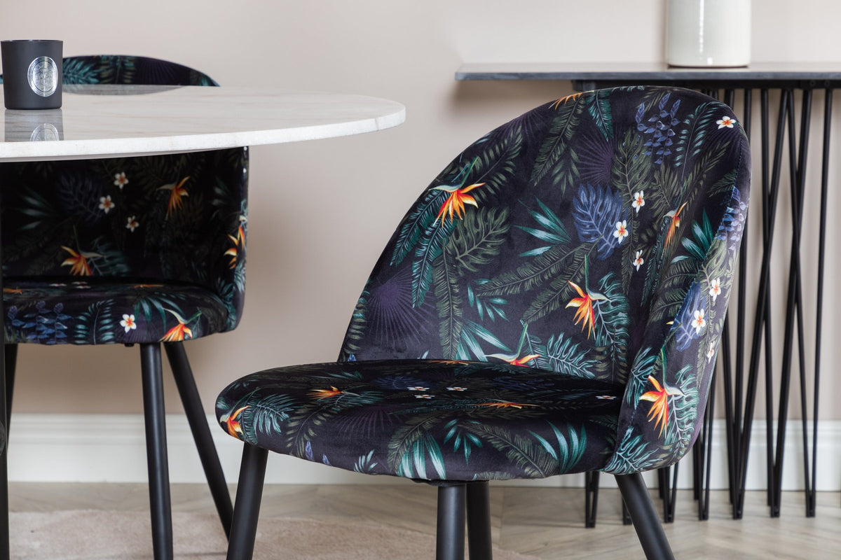 Esszimmertisch Estelle mit weisser Marmorplatte und Stahlgestell, dazu Samtstühle der Velvet-Serie mit schwarz pulverbeschichtetem Gestell
