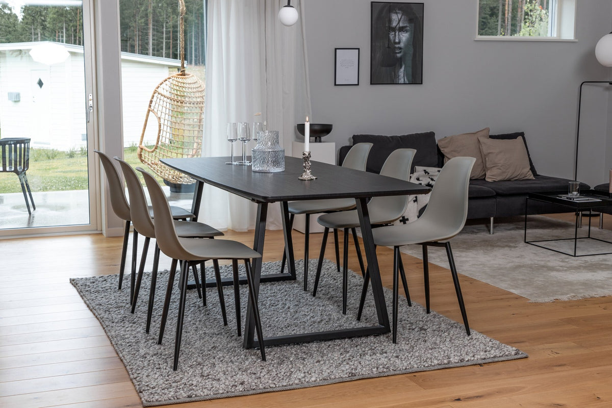 Grauer Esstisch mit schwarzer Tischplatte aus MDF und Stahl, dazu vier Esszimmerstühle mit schwarz pulverbeschichtetem Gestell.
