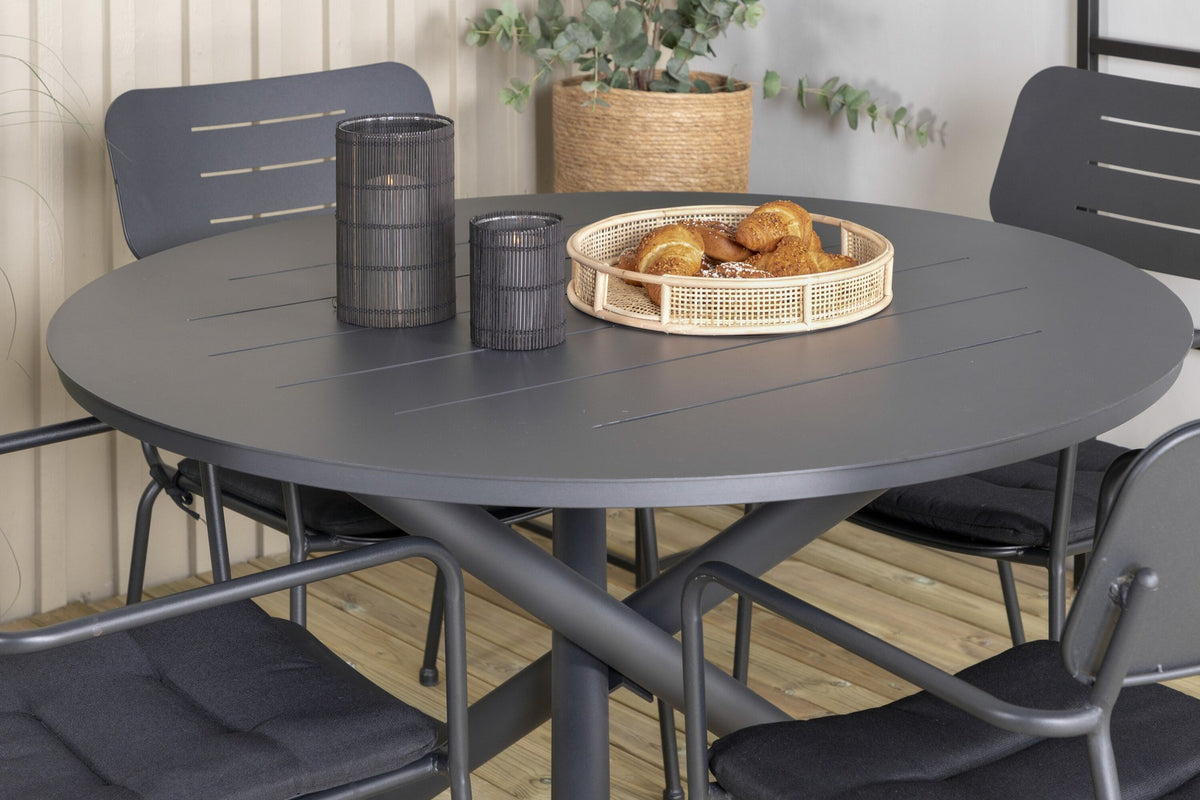 Zwei schwarze Aluminium-Stühle mit Armlehnen und Polyesterbezug neben rundem schwarzem Aluminium-Esstisch mit 120 cm Durchmesser im Freien.
