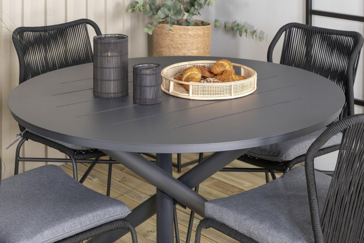 Runder Aluminium-Esstisch Ø120 cm in Schwarz mit Kreuzgestell und vier gepolsterten Esszimmerstühlen aus schwarzem Stahl, stapelbar, für den Outdoor-Bereich.