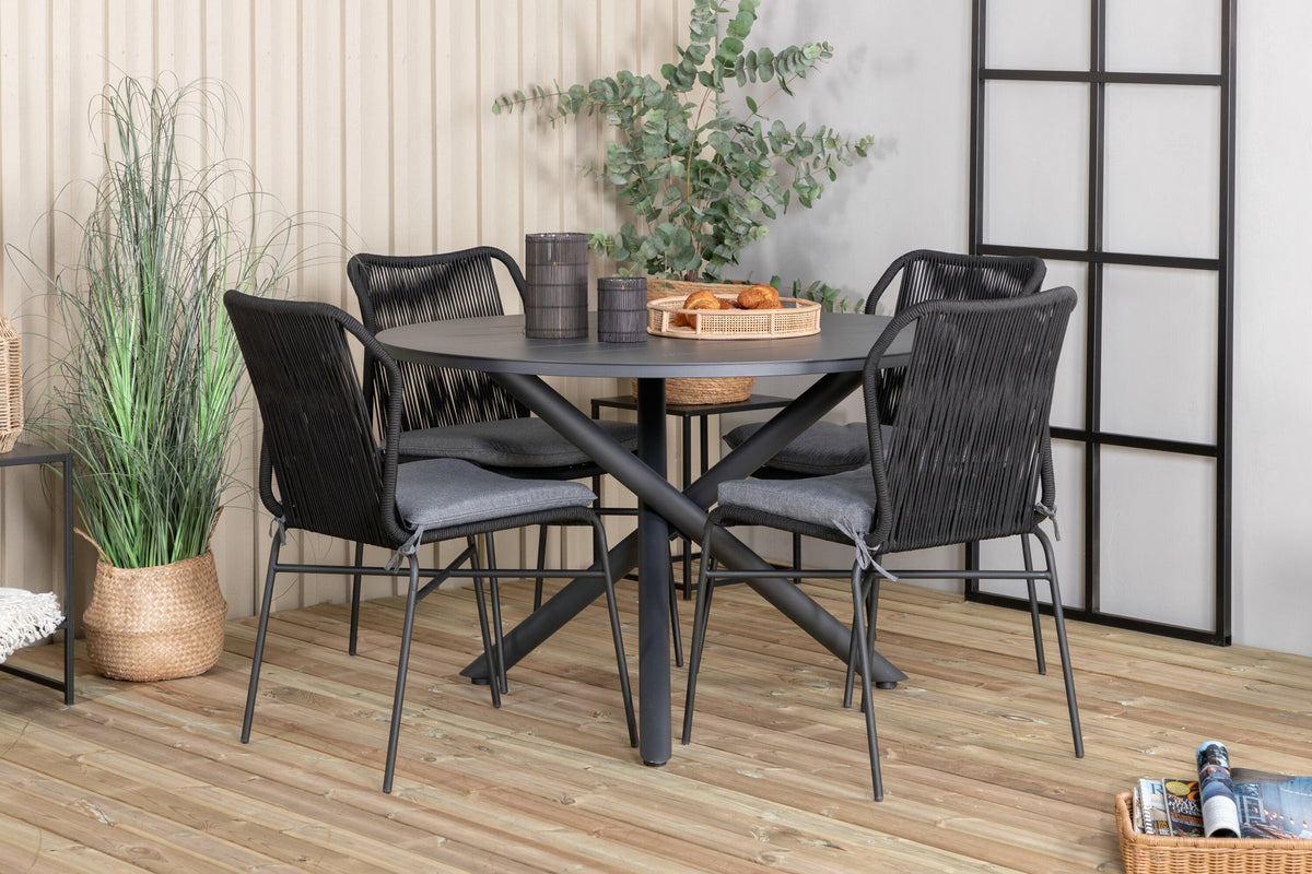 Runder Aluminium-Esstisch Ø120 cm in Schwarz mit Kreuzgestell und vier gepolsterten Esszimmerstühlen aus schwarzem Stahl, stapelbar, für den Outdoor-Bereich.