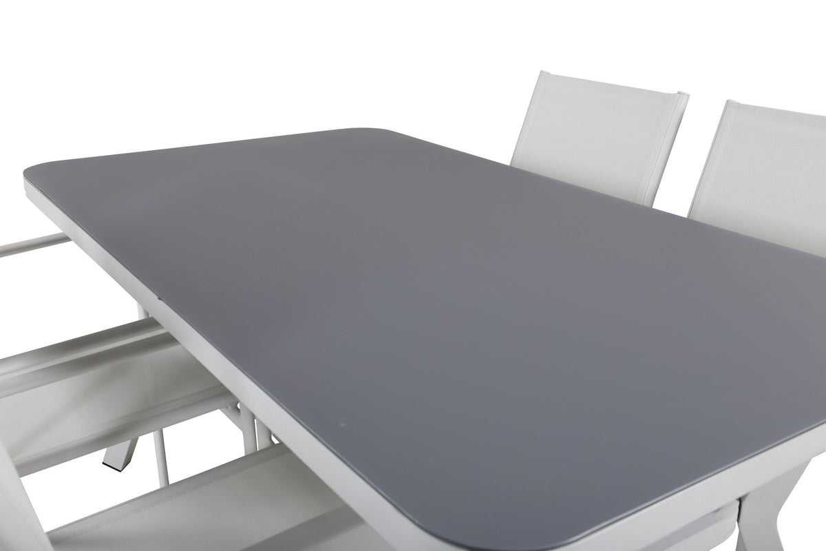 Rechteckiger Gartentisch mit schwarzer Mattglasplatte und Aluminiumbeinen, daneben zwei weisse Stühle aus Textilene mit Pulverbeschichtung.