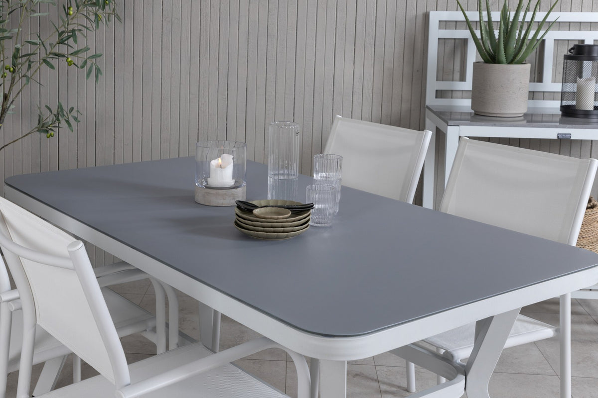Rechteckiger Gartentisch mit schwarzer Mattglasplatte und Aluminiumbeinen, daneben zwei weisse Stühle aus Textilene mit Pulverbeschichtung.