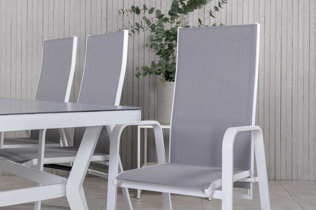 Rechteckiger Gartentisch mit Mattglas-Platte und Aluminiumbeinen, daneben zwei graue Relaxsessel aus Textilene von Venture Home.