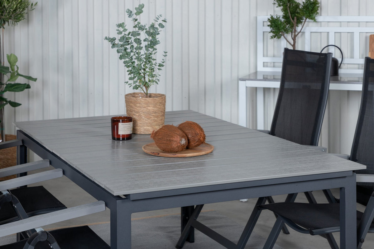Schwarzer Albany-Stuhl mit grauem Teakholz und Textilene neben ausziehbarem Levels Gartentisch aus Aluminium und Aintwood in Schwarz/Grau