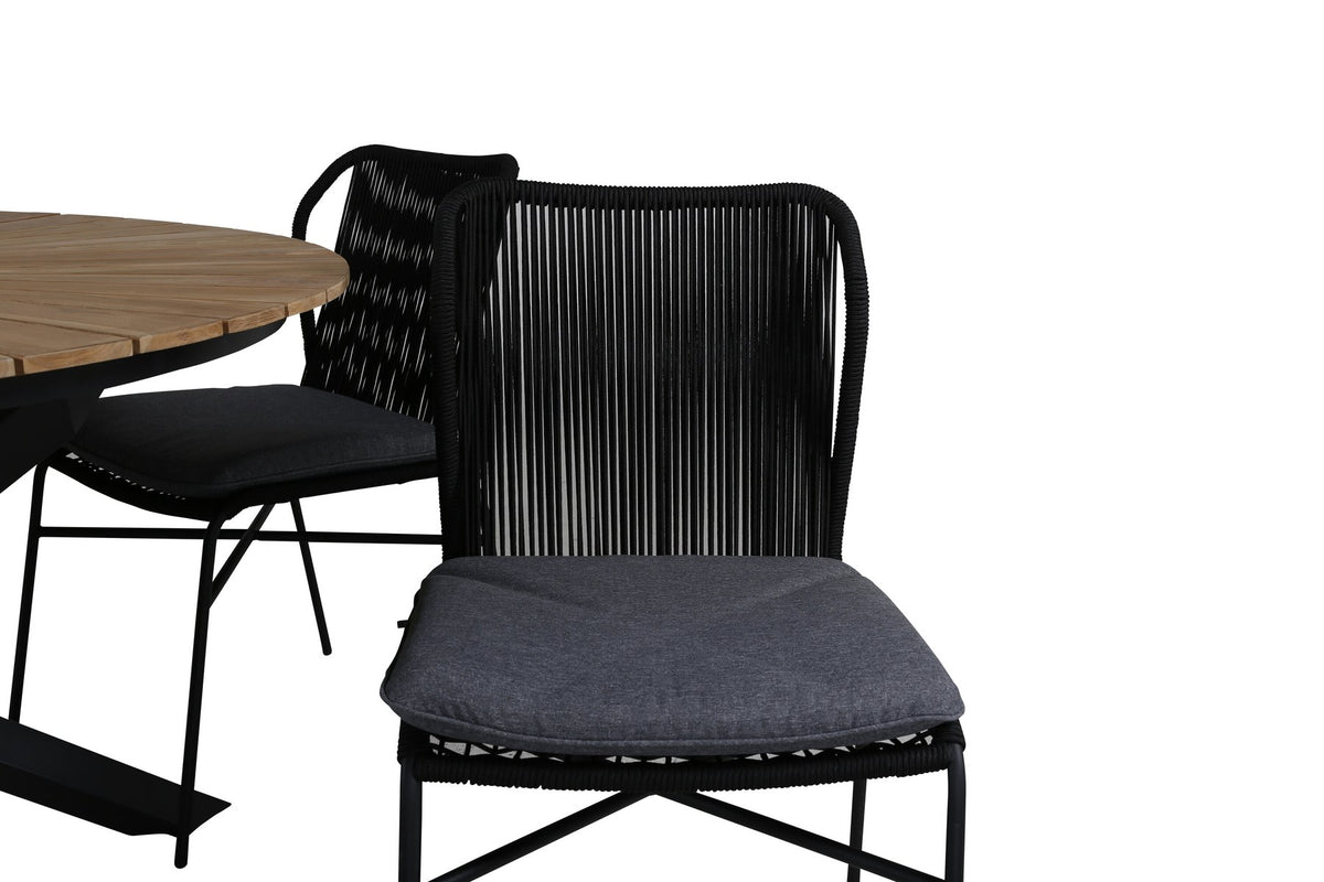 Vier schwarze Esszimmerstühle mit Aluminiumgestell und Polyesterbezug neben rundem Teak-Esstisch mit Stahlbeinen, Durchmesser 140 cm.