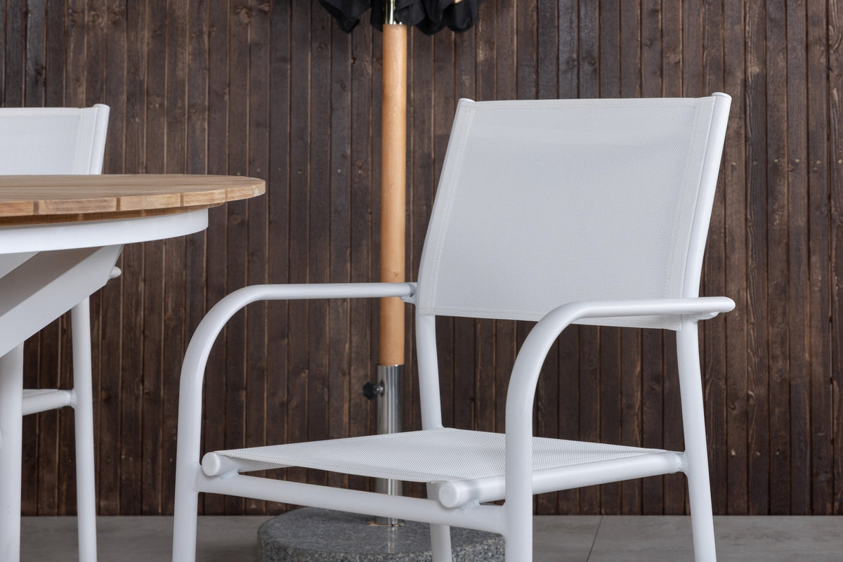 Runder Gartentisch mit Teakholz-Platte ⌀140 cm auf weissem Aluminiumgestell, daneben zwei weisse Aluminium-Stühle mit Pulverbeschichtung.