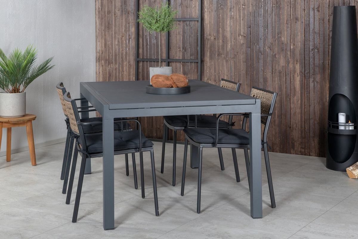 Vier Esszimmerstühle aus Aluminium mit Polyesterbezug in Natur und rechteckiger Esstisch mit schwarzer Aluminium-Tischplatte.