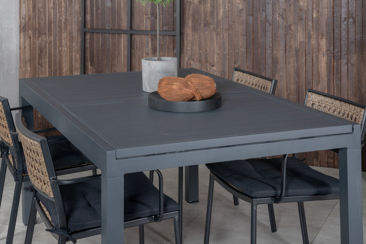 Vier Esszimmerstühle aus Aluminium mit Polyesterbezug in Natur und rechteckiger Esstisch mit schwarzer Aluminium-Tischplatte.