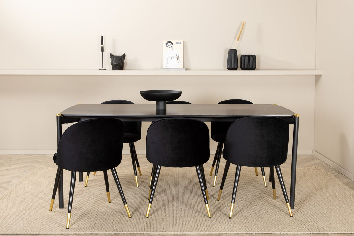 Schwarzer Esstisch aus MDF mit Furnier und Stahlbeinen, kombiniert mit sechs schwarzen Samtstühlen mit gepolstertem Sitz und Metallbeinen.