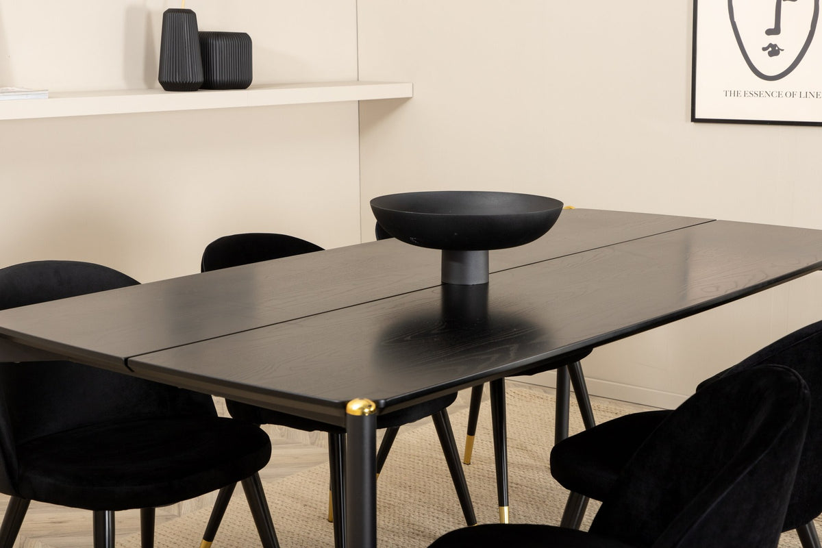 Schwarzer Esstisch aus MDF mit Furnier und Stahlbeinen, kombiniert mit sechs schwarzen Samtstühlen mit gepolstertem Sitz und Metallbeinen.