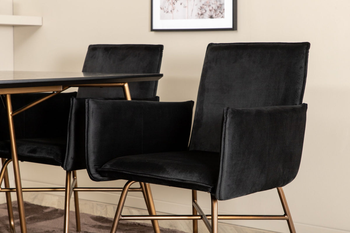 Petra Esszimmerset: Esstisch mit schwarzer MDF-Platte und Furnier in Used-Optik, sechs Stühle mit Samtbezug in Kupfer/Schwarz und Eisenbeinen.