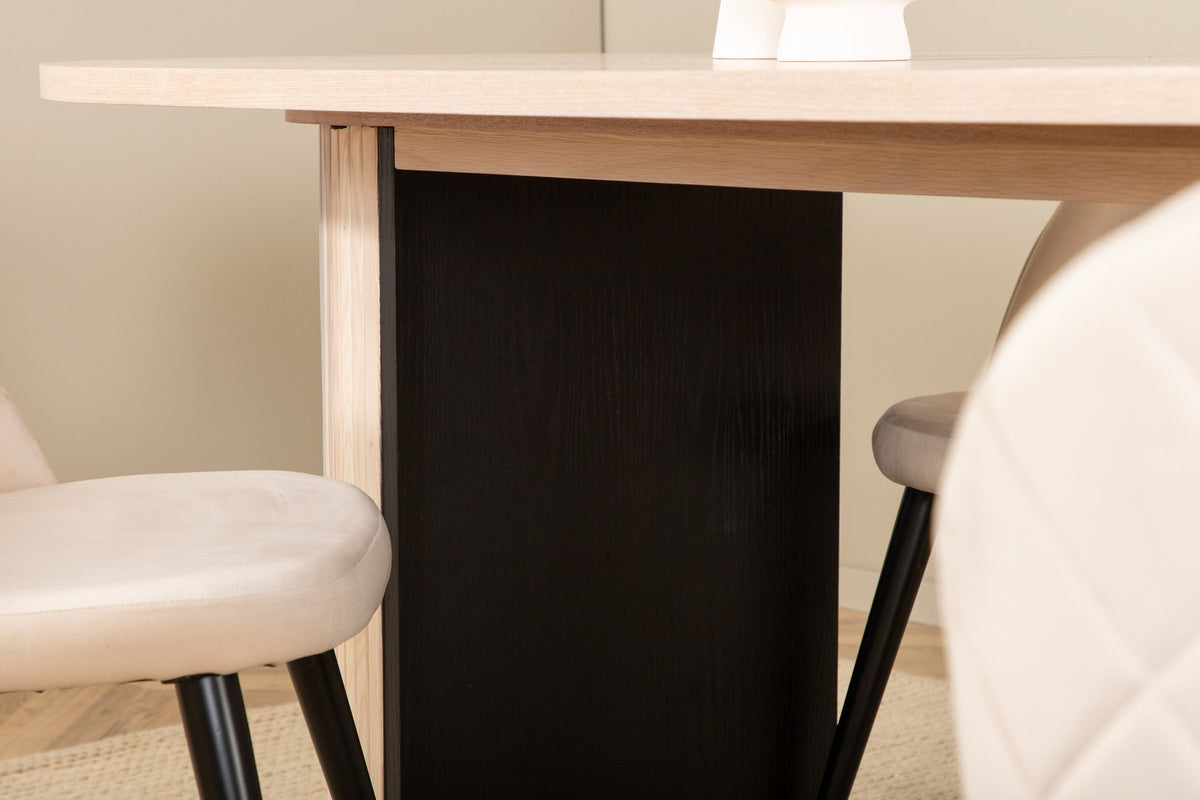 Ovaler Esstisch mit weiss gewaschenem schwarzem Furnier und vier Stühlen mit beige-schwarzem Polyester-Leinen-Bezug und Samtnähten