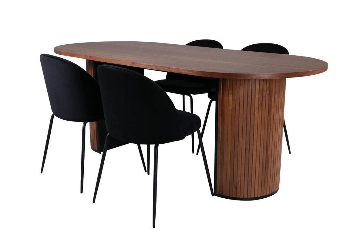 Zwei schwarz gepolsterte Esszimmerstühle mit Samtbezug und Metallgestell neben ovalem Esstisch mit Nussbaum-Furnierplatte und Stahlgestell.