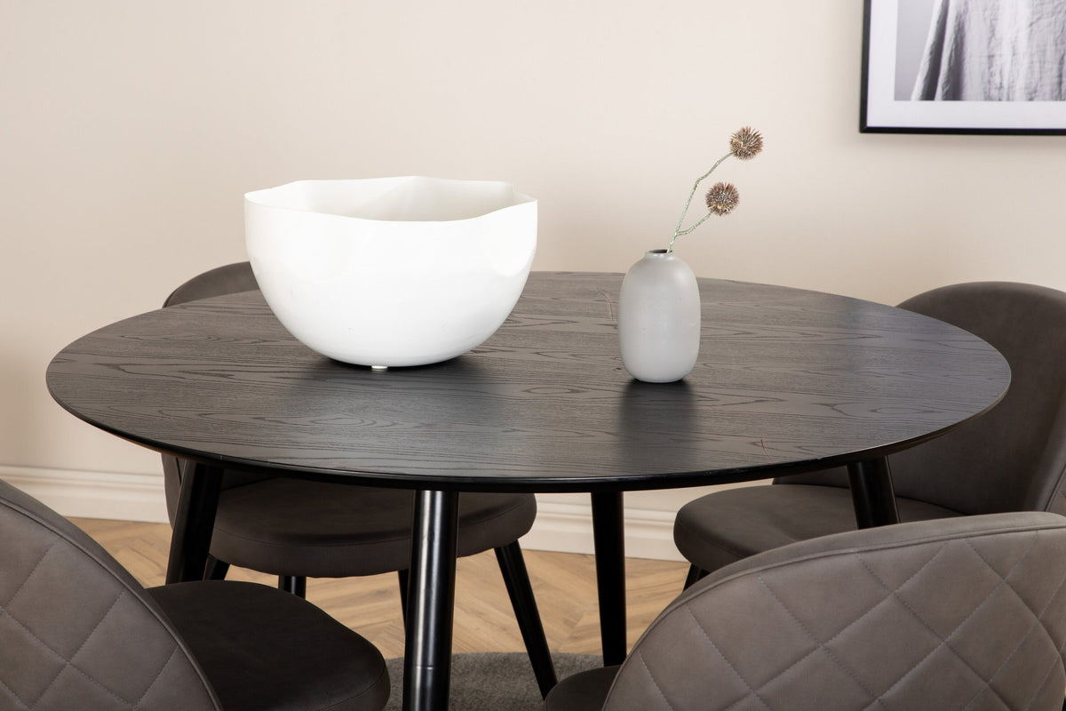 Rundes Dipp Esszimmerset: Esstisch ⌀115 cm mit schwarzem Furnier und schwarzen Beinen, dazu vier Velvet-Stühle mit schwarz-grauem Mikrofaserbezug.