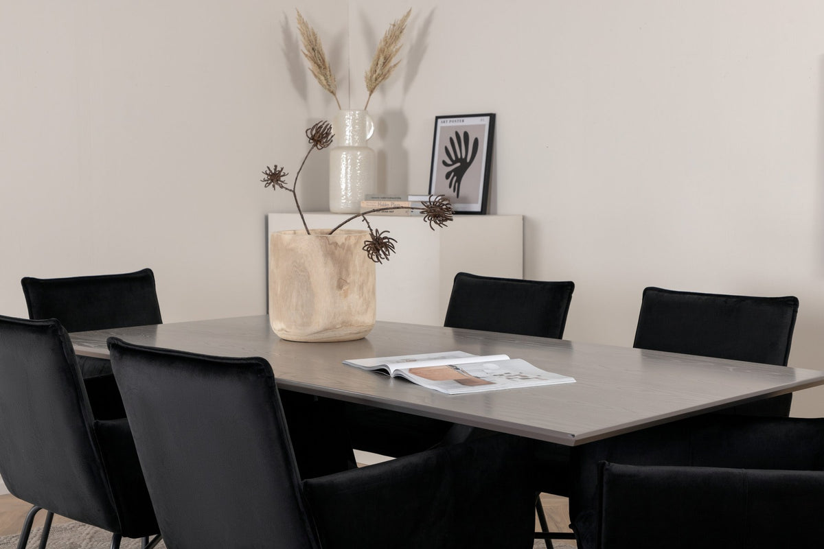 Esszimmerset mit rechteckigem Tisch, grauer MDF-Furnier-Platte, gekreuztem Stahlgestell und sechs Petra-Stühlen mit schwarzem Samtsitz.