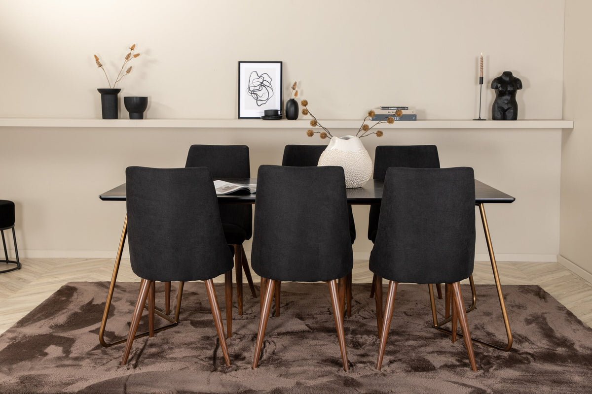 Rechteckiger Esstisch aus schwarzem MDF mit Furnier und Stahlbeinen, dazu zwei Esszimmerstühle mit schwarzer Sitzfläche und Metallgestell.
