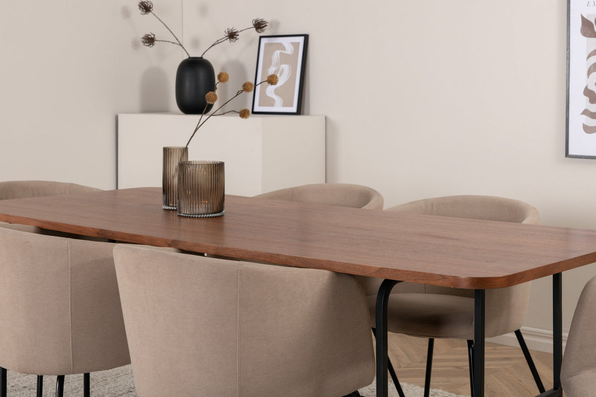 Esstisch mit Platte aus MDF und Walnussfurnier, schwarzem Metallgestell, kombiniert mit sechs Berit-Stühlen aus beigem Samtstoff und schwarzen Beinen.