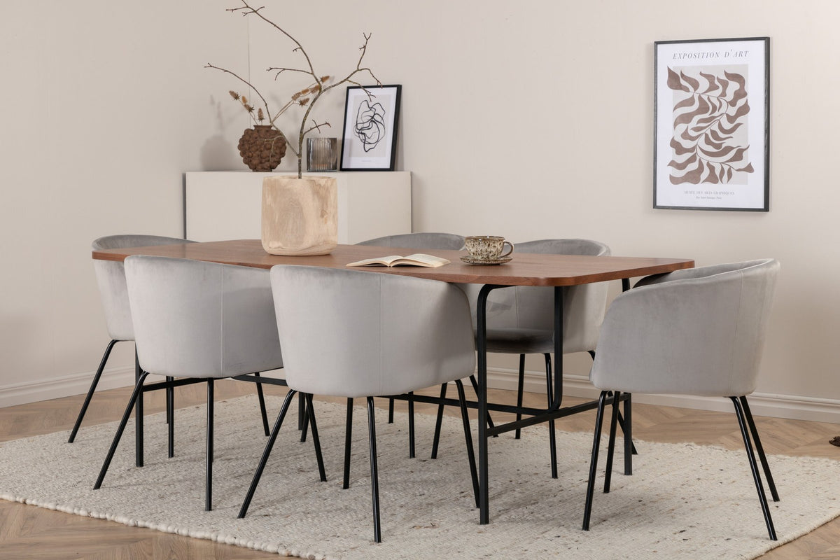 Esstisch mit Platte aus MDF und Walnussfurnier, schwarzem Metallgestell, kombiniert mit sechs Berit-Stühlen aus beigem Samtstoff und schwarzen Beinen.