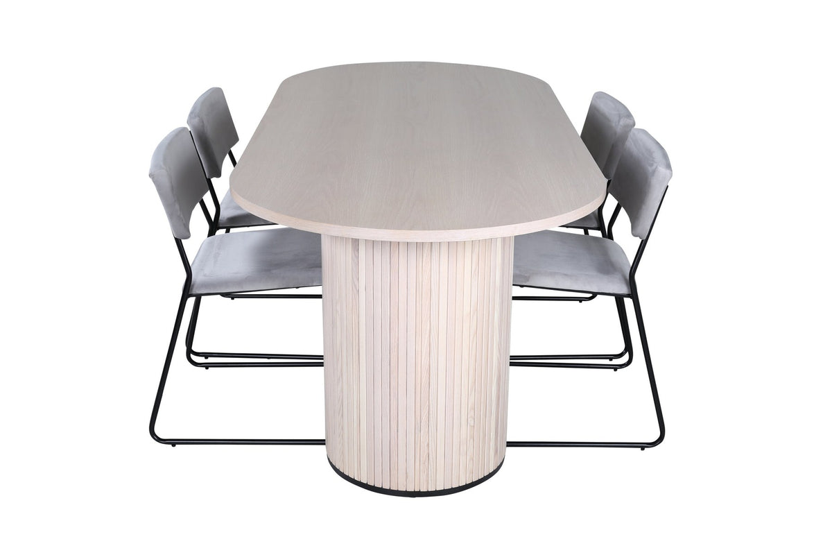 Zwei graue Esszimmerstühle mit schmalen schwarzen Beinen neben ovalem Esstisch mit MDF-Platte in Whitewash, Grösse 200x90 cm.