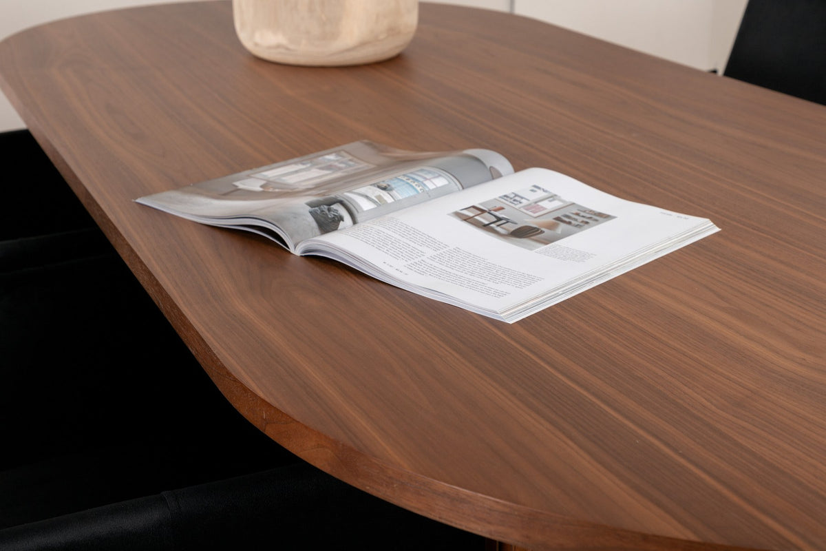 Ovaler Esstisch aus MDF mit Nussbaum-Furnier, 200x90 cm, kombiniert mit vier schwarzen Esszimmerstühlen mit pulverbeschichteter Oberfläche.